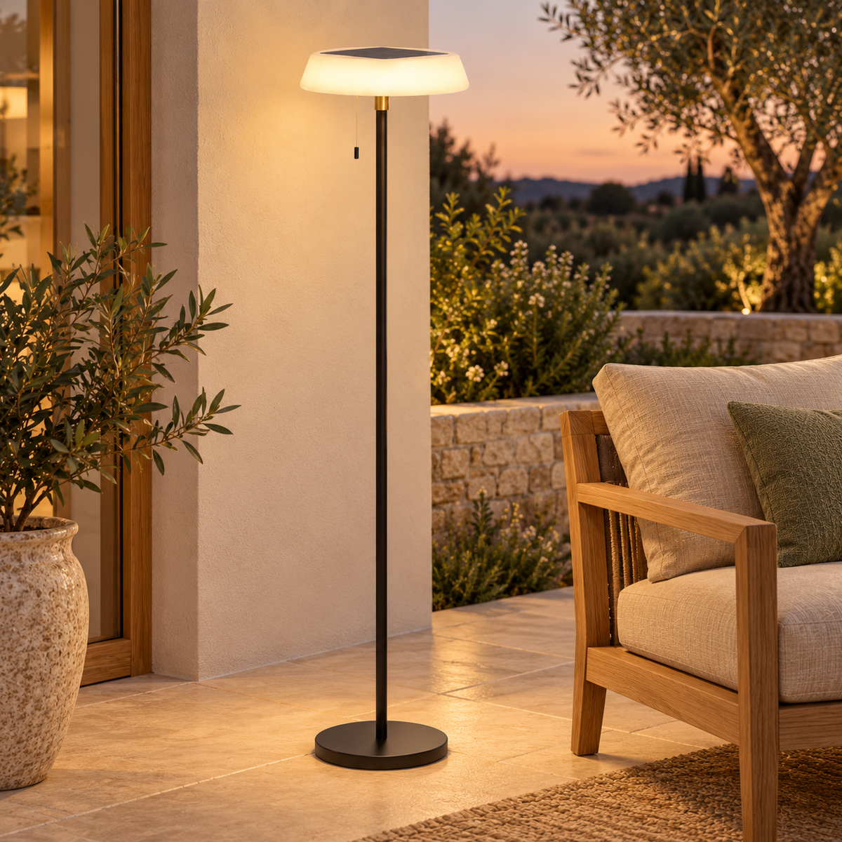 Lámpara de pie solar negra encendida en una terraza exterior, con panel superior y tirador