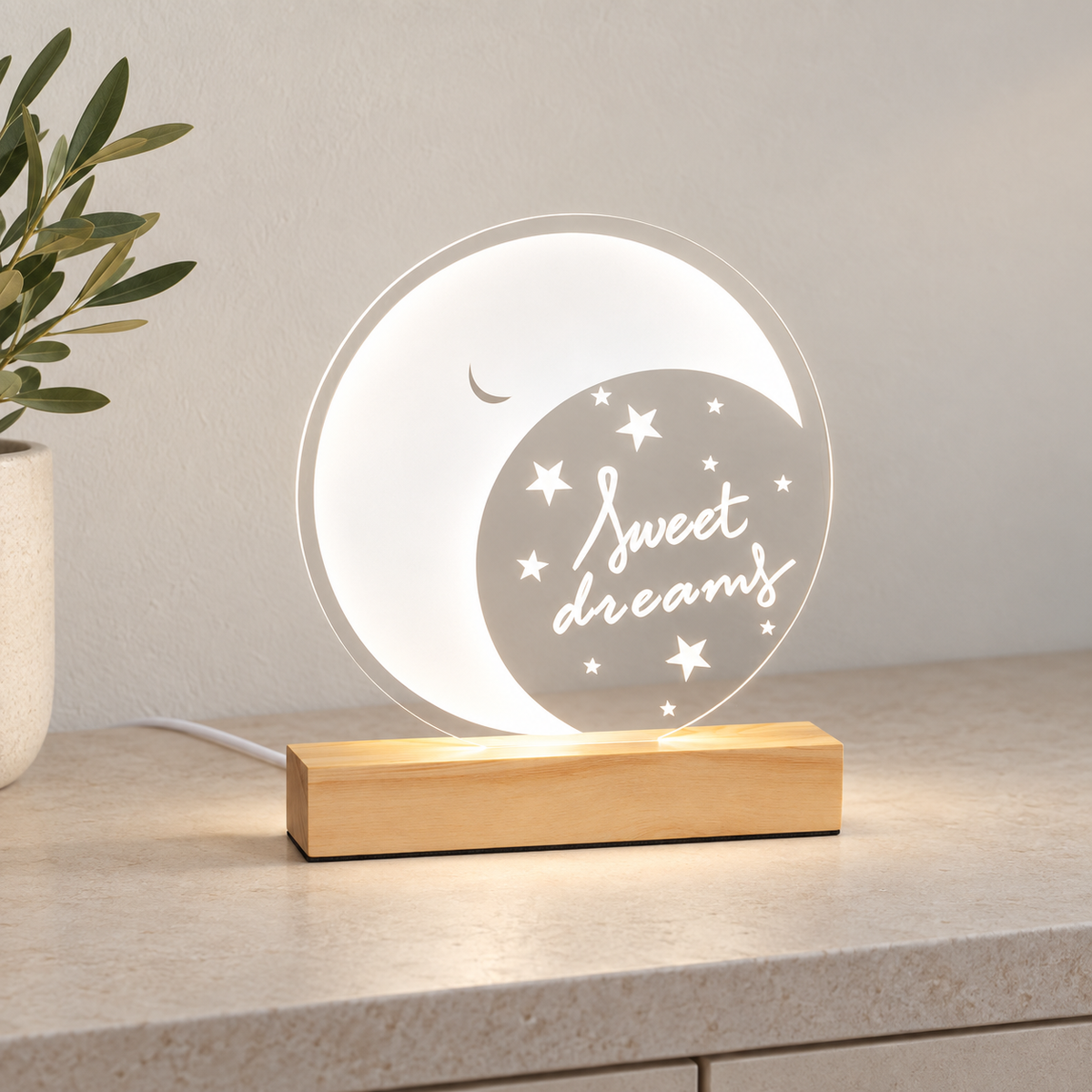 Lámpara de luna en disco transparente encendida con luz neutra sobre consola clara