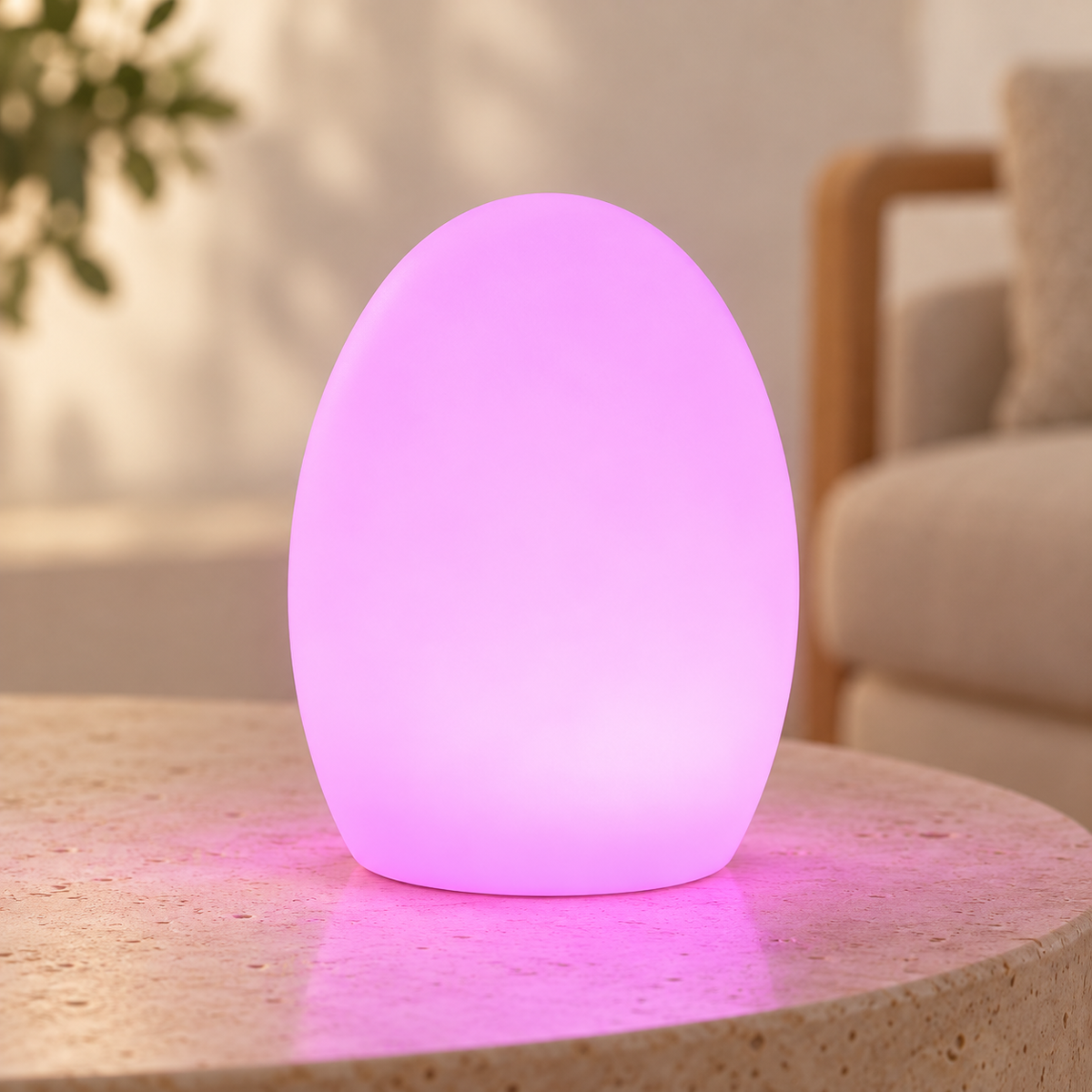 Lámpara oval recargable con LED RGB encendida en tono lila sobre mesa clara