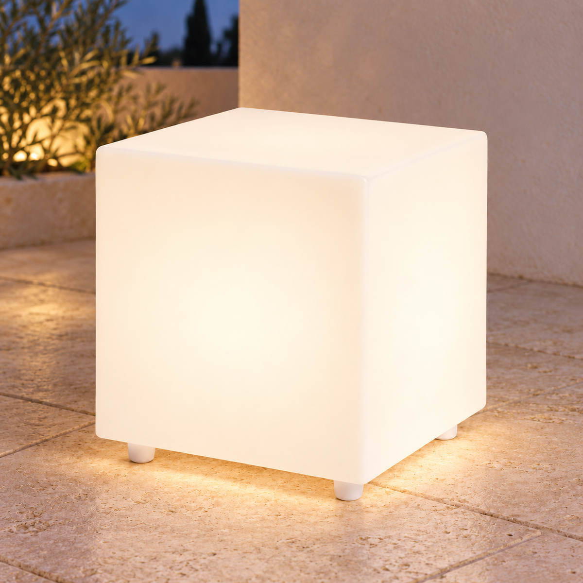 Cubo LED blanco con iluminación cálida en una terraza al anochecer