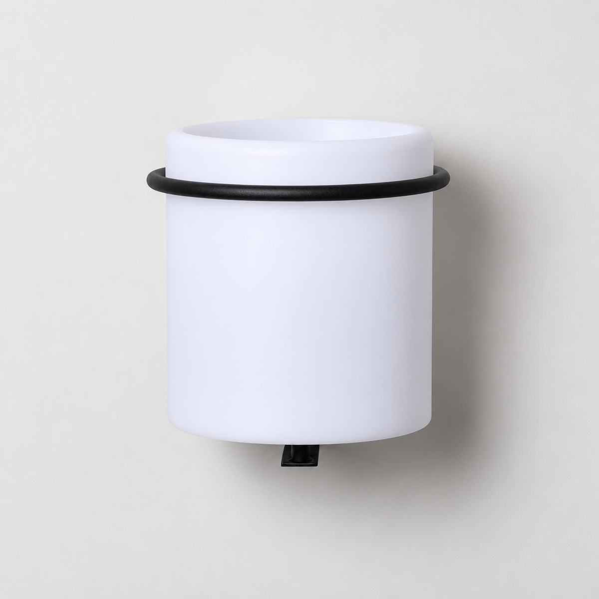 Macetero luminoso apagado de color blanco con soporte negro sobre pared clara