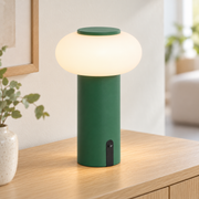 Lámpara de mesa recargable verde encendida con difusor opal en un ambiente interior claro