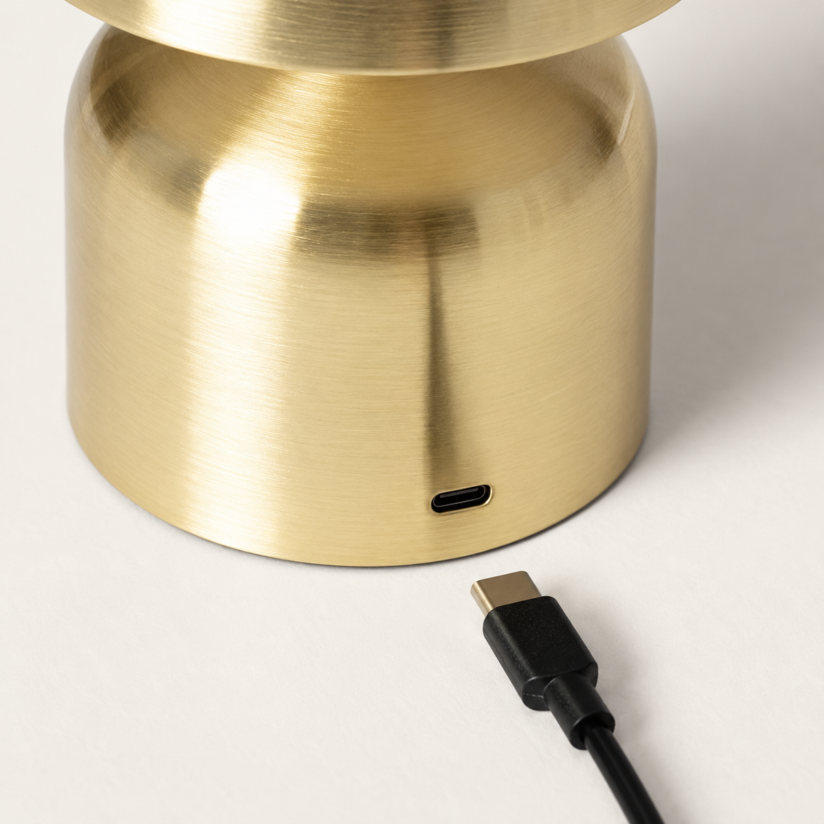 Detalle del puerto de recarga USB-C en la base dorada