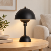 Lámpara de mesa negra con cúpula encendida en un salón interior