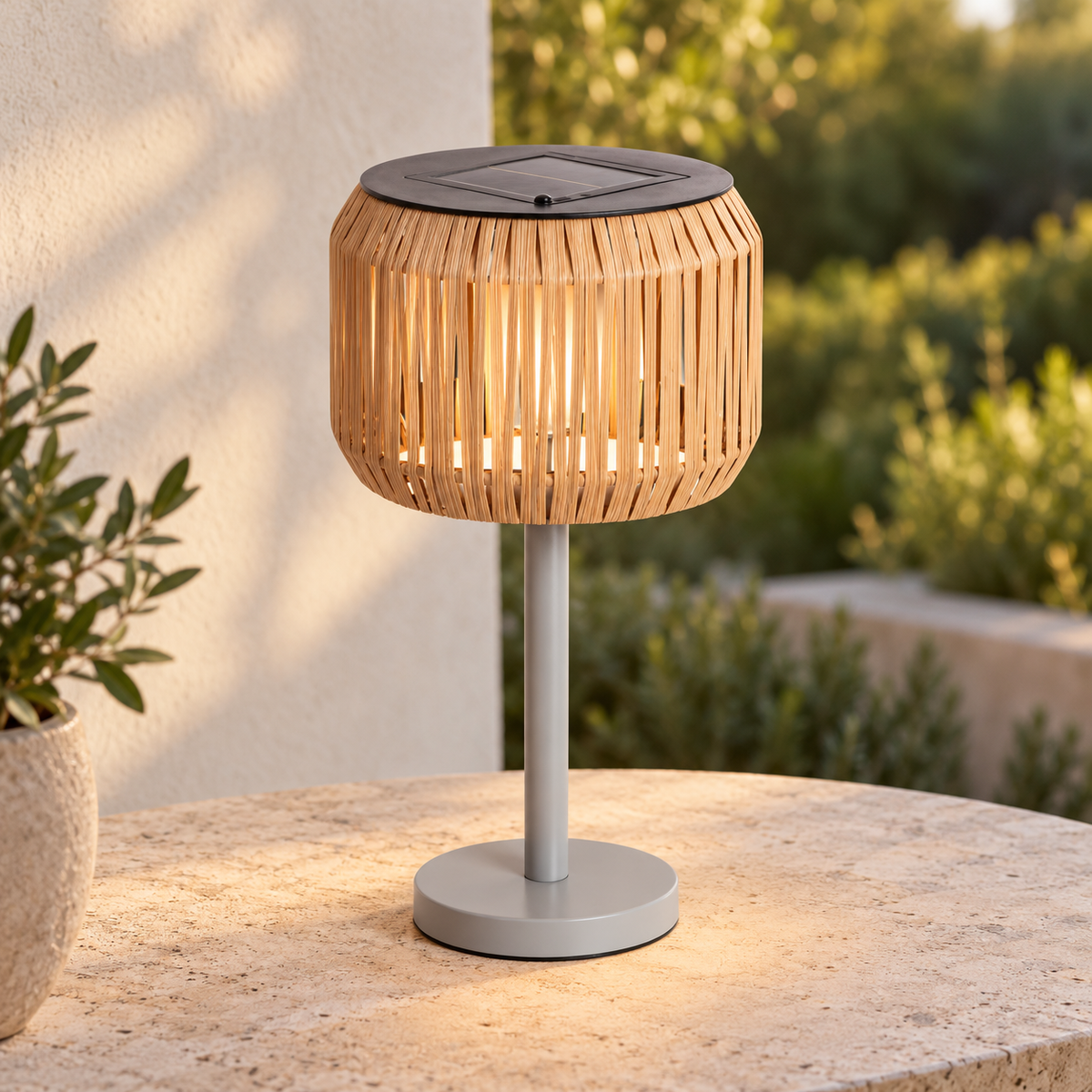 Lámpara solar de ratán natural encendida sobre una mesa de terraza