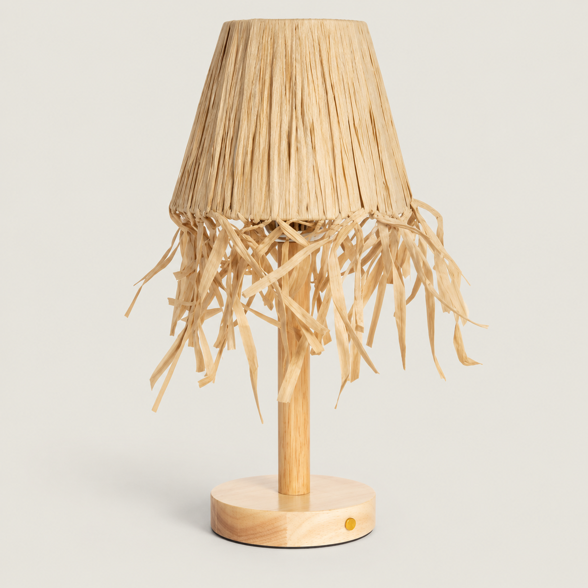 Lámpara de mesa apagada con base de madera y pantalla de rafia natural con flecos