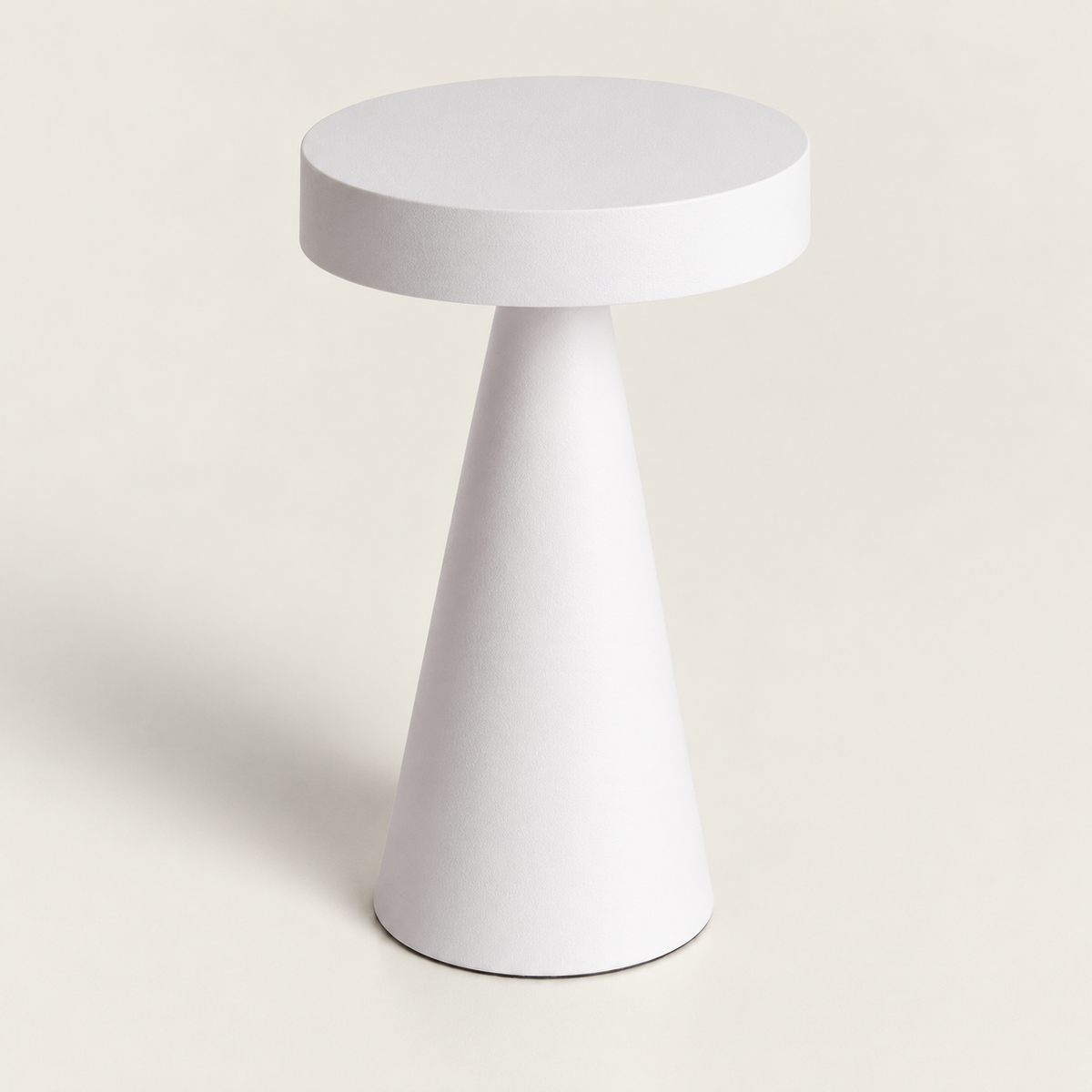 Lámpara de mesa blanca de disco y base cónica apagada sobre fondo claro