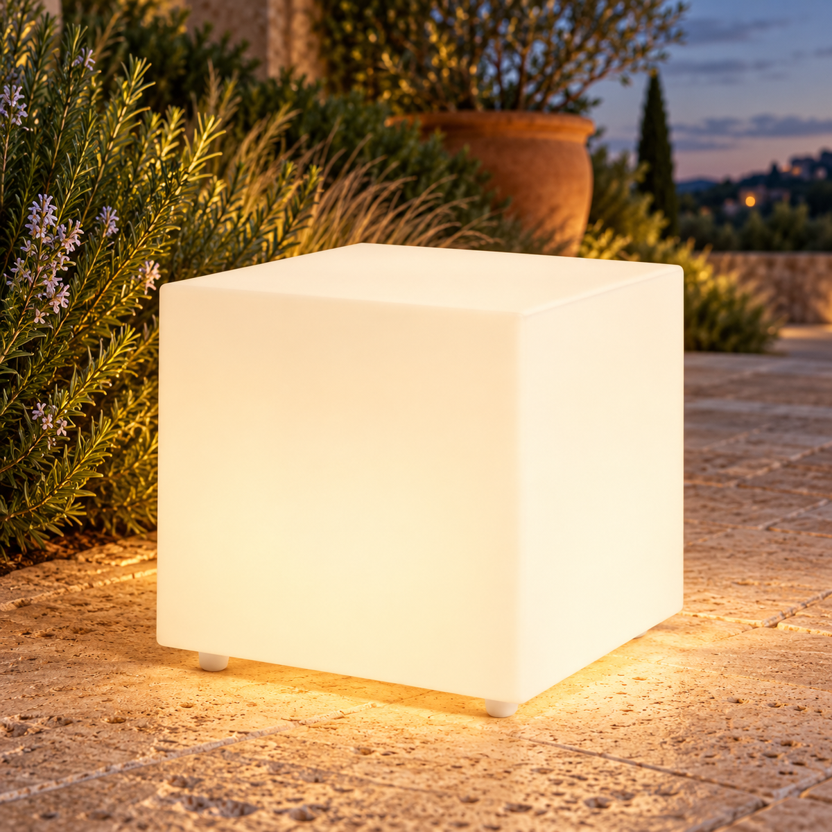 Cubo decorativo LED LedsCome de 38 cm con luz cálida en un jardín al atardecer. Representación ambiental.