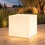 Cubo decorativo LED LedsCome de 50 cm con luz cálida en un jardín al atardecer. Representación ambiental.