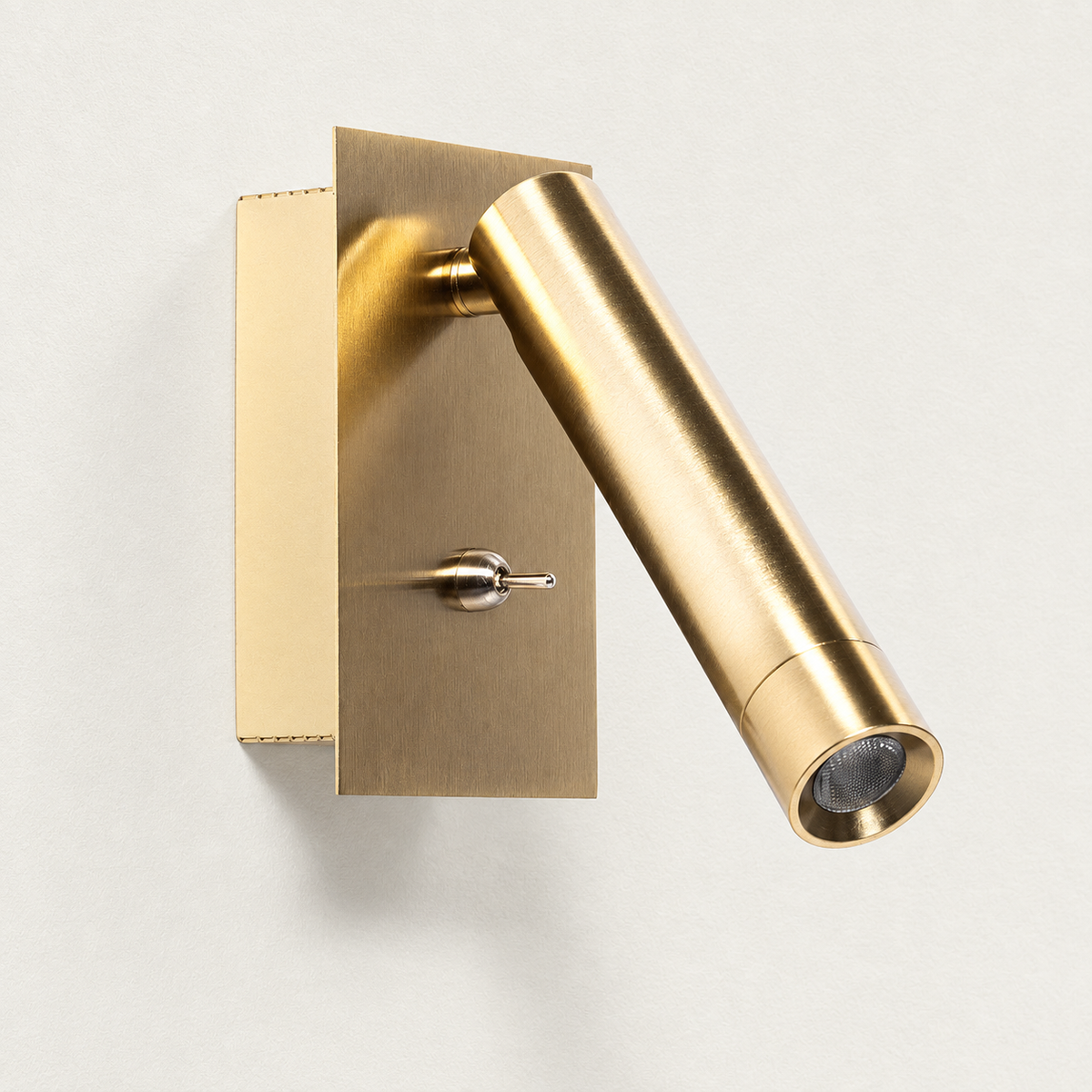 Aplique dorado apagado con placa rectangular, foco cilíndrico orientable e interruptor de palanca