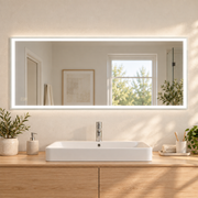Espejo panorámico de baño de 150 por 60 centímetros con borde LED encendido sobre mueble de madera clara