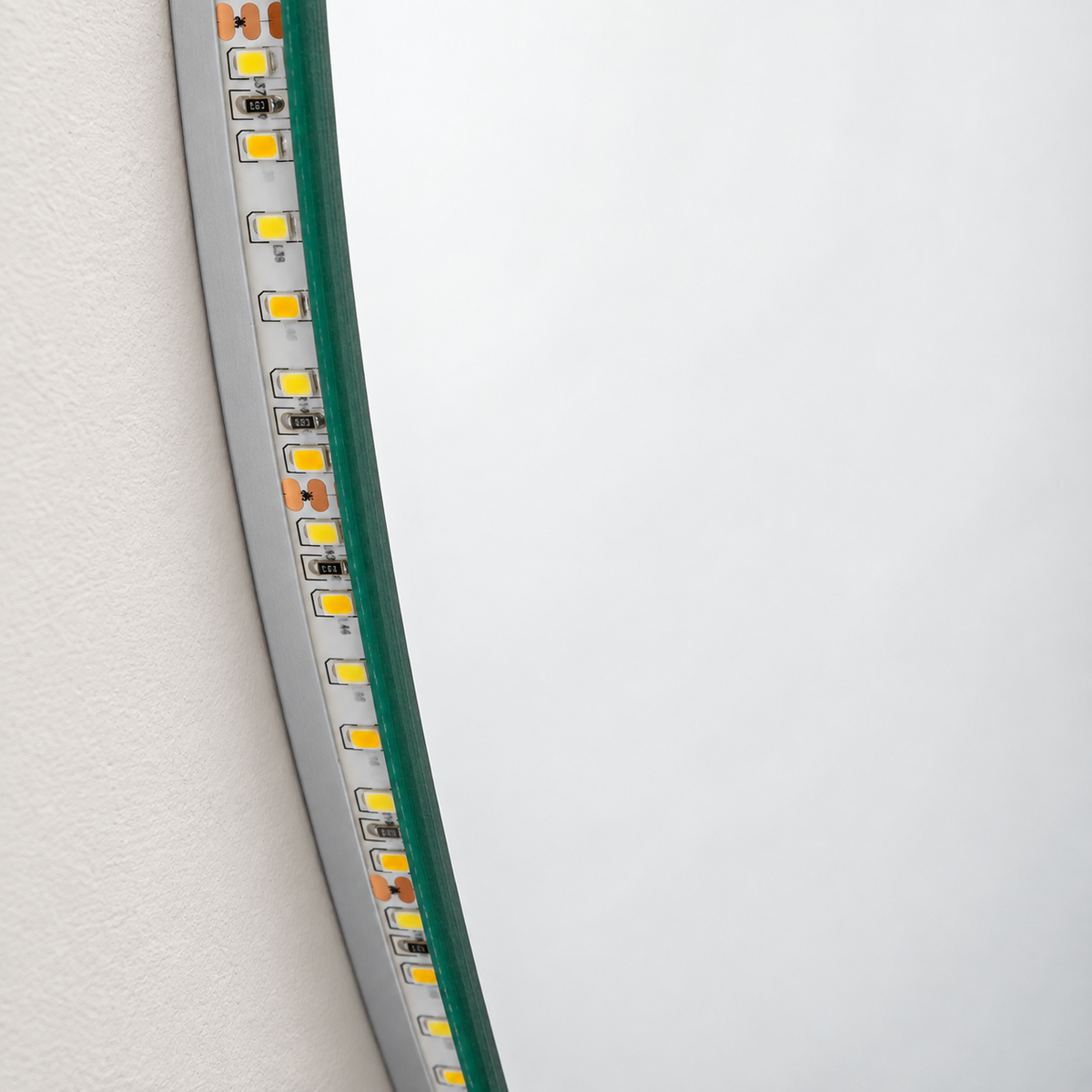 Detalle del canto de cristal y la tira LED posterior apagada del espejo ovalado
